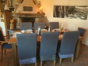 Meine Fischerhütte في بورغيريندي-ريثفيش: غرفة طعام مع طاولة وكراسي ومدفأة