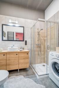 a bathroom with a shower and a sink and a washing machine at Best4Stay Apartment - z prywatnym parkingiem in Toruń