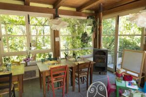 ein Esszimmer mit einem Tisch, Stühlen und Fenstern in der Unterkunft Alpaca country house in Pontedera