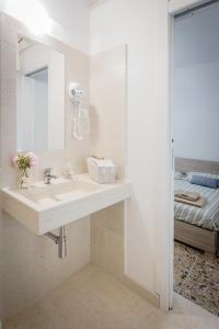 un bagno con lavandino, specchio e letto di "Un Posticino Carino" Camere Cagliari a Cagliari