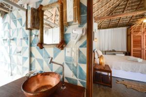 a bathroom with a wooden tub in a room with a bed at Manati in Barra Grande