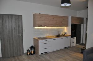 cocina con armarios blancos y lavabo en una habitación en Apartament LAZUROWY Pięć Mórz - Sianożęty en Sianozety