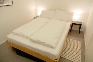 a bed with white sheets and pillows in a room at Apartments near Augarten in Vienna