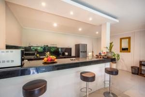 a kitchen with a counter and stools in a room at Villa Rani 3 in Seminyak
