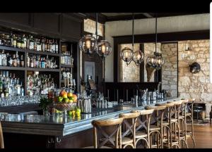 bar z kilkoma stołkami barowymi w pokoju w obiekcie The Kendall w mieście Boerne