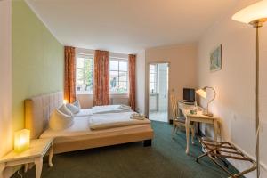 a bedroom with a bed and a desk with a computer at Hotel Overdiek in Prenzlau