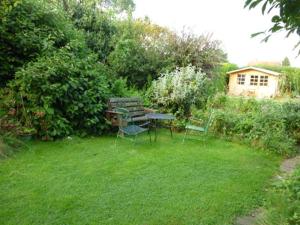 a garden with a table and chairs in the grass at Calne Bed and Breakfast in Calne