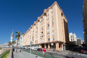 a large building on a city street with a person crossing the street at GAVIOTA Family Home free parking by Cadiz4Rentals in Cádiz