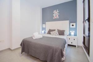 1 dormitorio con 1 cama grande y pared azul en EnjoyGranada REALEJO DELUXE 1A, en Granada