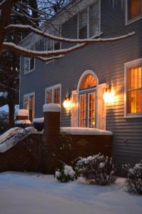 uma casa com luzes acesas na neve em The Inn at Union Pier em Union Pier