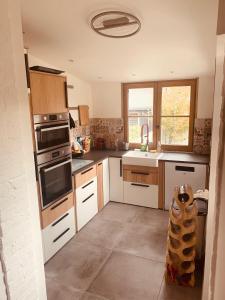 eine Küche mit weißen Schränken und einem Herd mit Backofen in der Unterkunft Villa Sainte Claire in Saint-Malo + 28 Fotos