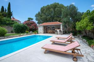 una piscina con 2 tumbonas y una casa en Villa Bruna, en Dubrovnik