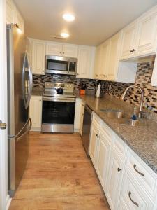 a kitchen with white cabinets and stainless steel appliances at Cape Coddages I 103 Condo in Myrtle Beach