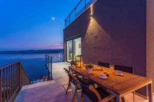 a wooden table on the balcony of a house at Villa Mia with private pool, Whirlpool, gym, sauna, seaviews in Lokva Rogoznica
