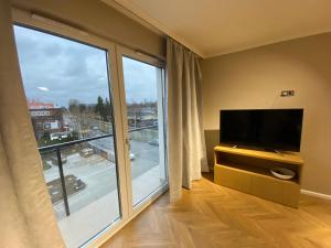 uma sala de estar com uma grande janela e uma televisão de ecrã plano em Apartament Wrocław Marina nad Odrą 7 em Breslávia