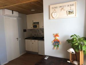 a kitchen with a white wall with a sign that reads home sweet home at Habitación en Calle Molino in Málaga