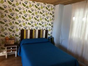 1 dormitorio con 1 cama con edredón azul en Habitación en Calle Molino, en Málaga