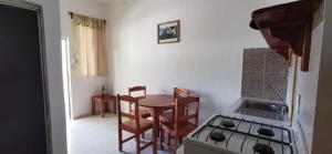 a kitchen with a table and a stove and a table and chairs at Hotel Iker in Tulum