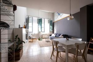 un soggiorno con tavolo e sedie bianchi di Bravissimo Home & Bike Girona a Girona