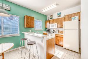 a kitchen with wooden cabinets and a white refrigerator at Leeward Isles in Corpus Christi