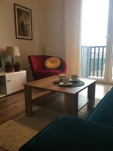 ein Wohnzimmer mit einem Couchtisch und einem roten Stuhl in der Unterkunft SWING in Stettin