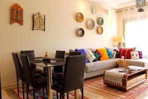 sala de estar con mesa y sofá en Hara Appart Luxe famille uniquement en Saidia 