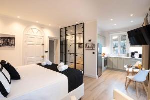 sypialnia z dużym białym łóżkiem i kuchnią w obiekcie Porta Reale Suite by CorfuEscapes w Korfu