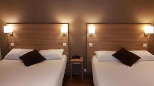 ディジョンにあるホテル モンシャペ ディジョン センターのベッド2台が隣同士に設置された部屋です。