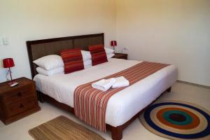 a bedroom with a large bed with two towels on it at Los Depas del Aeropuerto Holbox in Holbox Island
