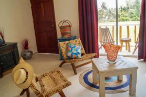 a living room with chairs and a table at Los Depas del Aeropuerto Holbox in Holbox Island