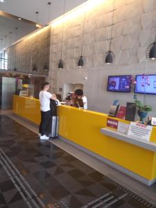 two people standing at a counter in a restaurant at Aparthotel Condomínio Mondial in Salvador