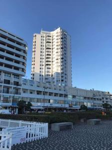 two tall buildings and a white fence in front of a building at Apartamentos Solmar 15º in Ponta Delgada