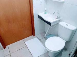 a bathroom with a toilet and a sink at Hotel Edinik in Cafelândia
