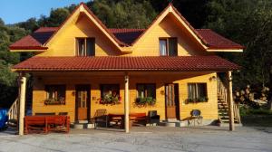 uma pequena casa amarela com um telhado vermelho em Complex turistic Nora Rau Sadului em Rau Sadului