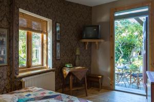 a bedroom with a bed and a tv and a window at Fontaine Valhalla Hotel in Liepāja