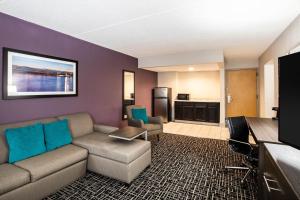 a living room with a couch and a kitchen at La Quinta Inn by Wyndham Davenport & Conference Center in Davenport