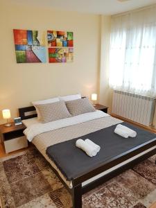 een slaapkamer met een groot bed en 2 handdoeken bij Apartman Harmony in Smederevo