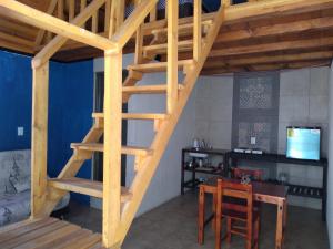 escalera de madera en una habitación con mesa y sillas en GoEs Loft, en Comitán de Domínguez