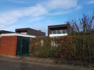 a house with a green door in front of a fence at Sandburg in Schillig
