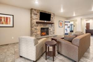 a living room with two chairs and a fireplace at Cobblestone Inn & Suites - Kermit in Kermit