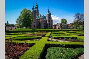 un jardín con un castillo en el fondo en The heart of Copenhagen-Queen's Neighbor, en Copenhague