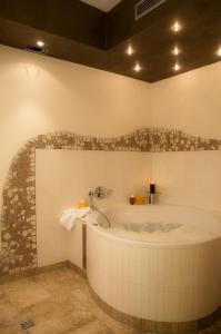 a bath tub in a bathroom with a stone wall at Hotel Schuberths am Schloss in Buttenheim