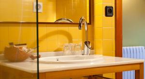 - Baño con lavabo y pared amarilla en Hotel Torre De Villademoros, en Luarca 37 fotos más