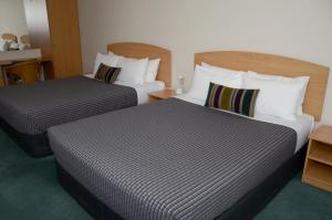 A bed or beds in a room at Greenlane Manor Motel