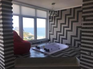 a bathroom with a tub and a large window at M&P VIP Appartments in Arkadia in Odesa