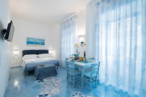 a bedroom with a bed and a table with chairs at Una Finestra sul Mare in Maiori