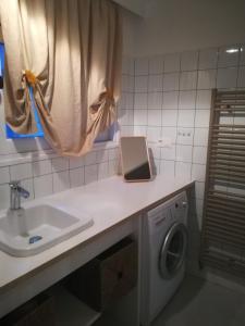 ein Badezimmer mit einem Waschbecken und einer Waschmaschine in der Unterkunft TY KERLUZ in Locquirec