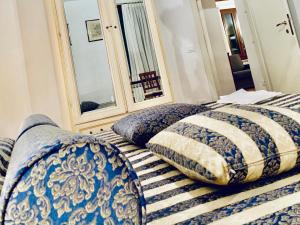 a bed with blue and white pillows and a mirror at Furlani house 6 in Venice