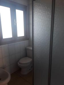 a bathroom with a toilet and a window at Apart Hotel Dolce Vita in Ovalle