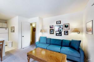 a living room with a blue couch and a table at Edelweiss Ski-In-N-Out & Unwind on Picabo St in Ketchum